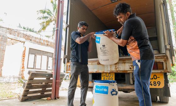 Trabajadores humanitarios en Sri Lanka, descargan una donación de UNICEF de botellas de hipoclorito de calcio como parte del proceso de suministro para la respuesta a las inundaciones.